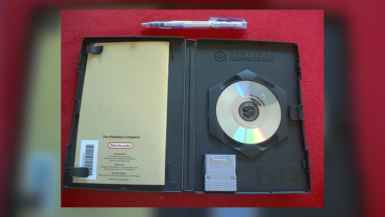 A small GameCube disc and memory card in an open game case